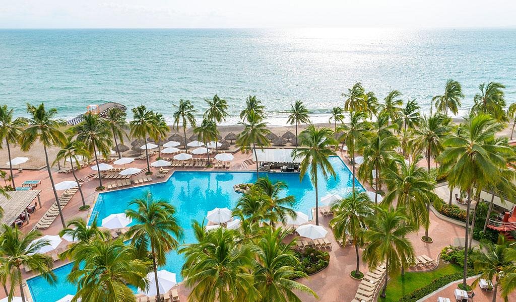 Sheraton Buganvilias Resort & Convention Center in Puerto Vallarta with oceanfront pools, palm trees, and Hotel Zone beachfront setting.