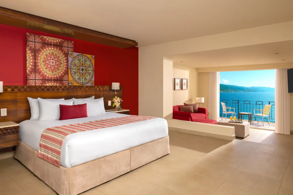 Sun Club Junior Suite Ocean Front with king bed, semi-private living area, and ocean view balcony at Sunscape Puerto Vallarta Resort & Spa.